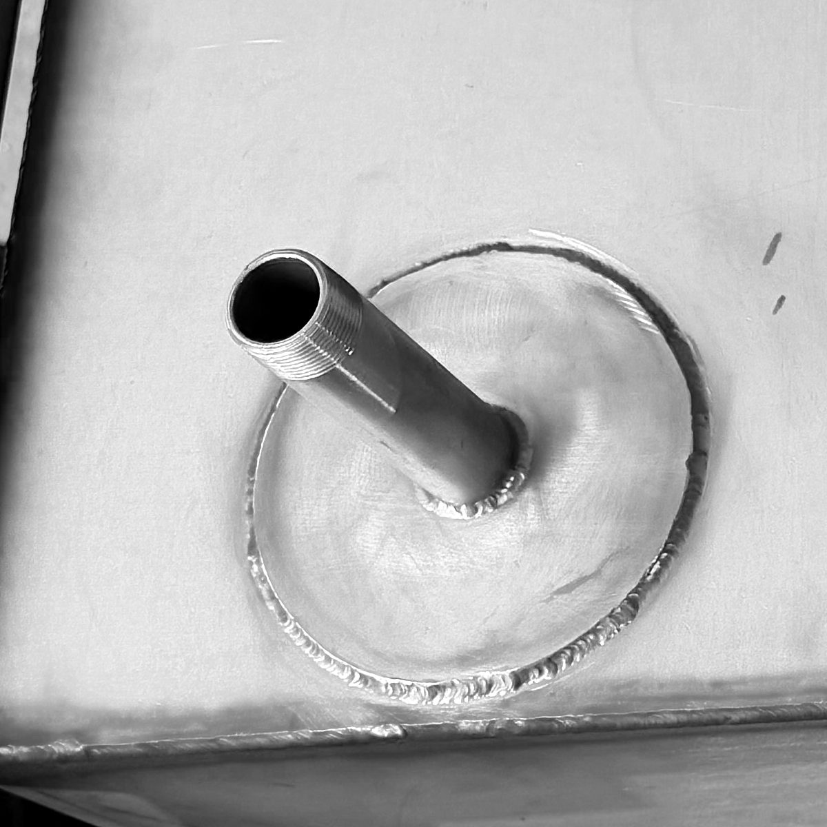 6-inch reinforcement pad welded around the 1-inch side drain fitting near the bottom of the tank wall